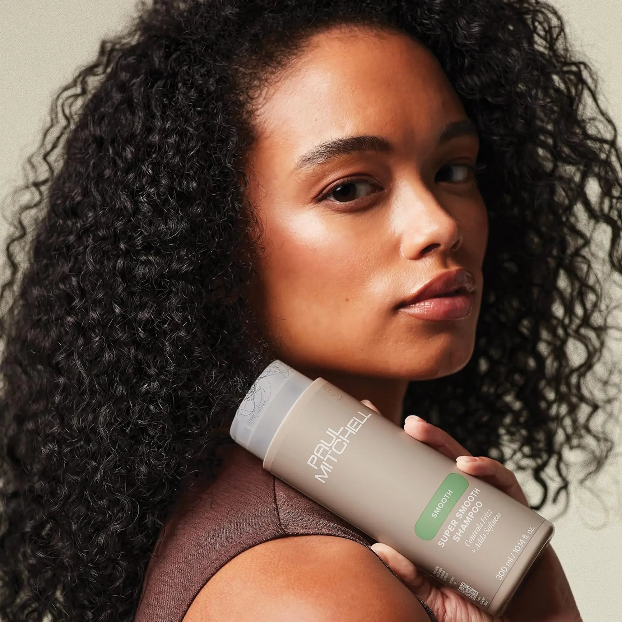 outeille de shampoing Paul Mitchell Super Smooth 300ml: beige avec étiquette verte, pour contrôler les frisottis et ajouter de la douceur.