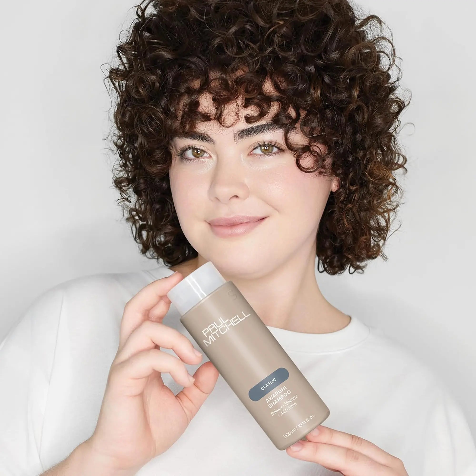 Bouteille de shampoing Paul Mitchell Classic Awapuhi 300ml : de couleur beige avec étiquette bleu-vert, pour équilibrer l'hydratation, ajouter de la brillance et éliminer l'accumulation de résidus.