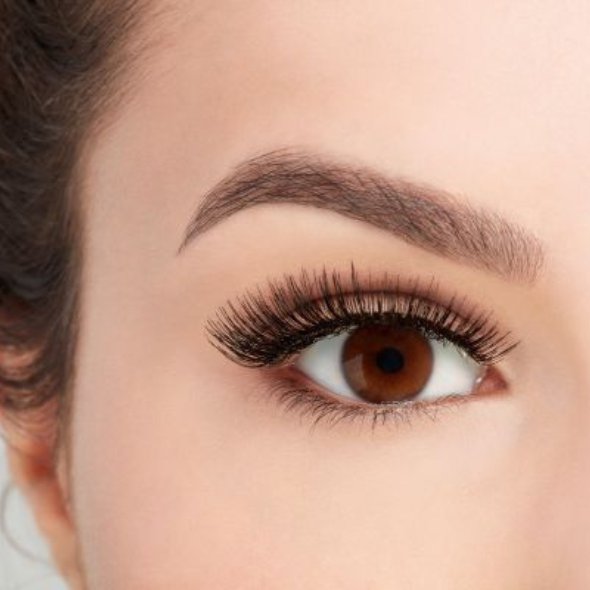 Boîtier transparent de la marque Ardell, modèle Natural 105. Les faux-cils noirs sont posés sur un support blanc, montrant une bande invisible transparente pour un effet naturel.