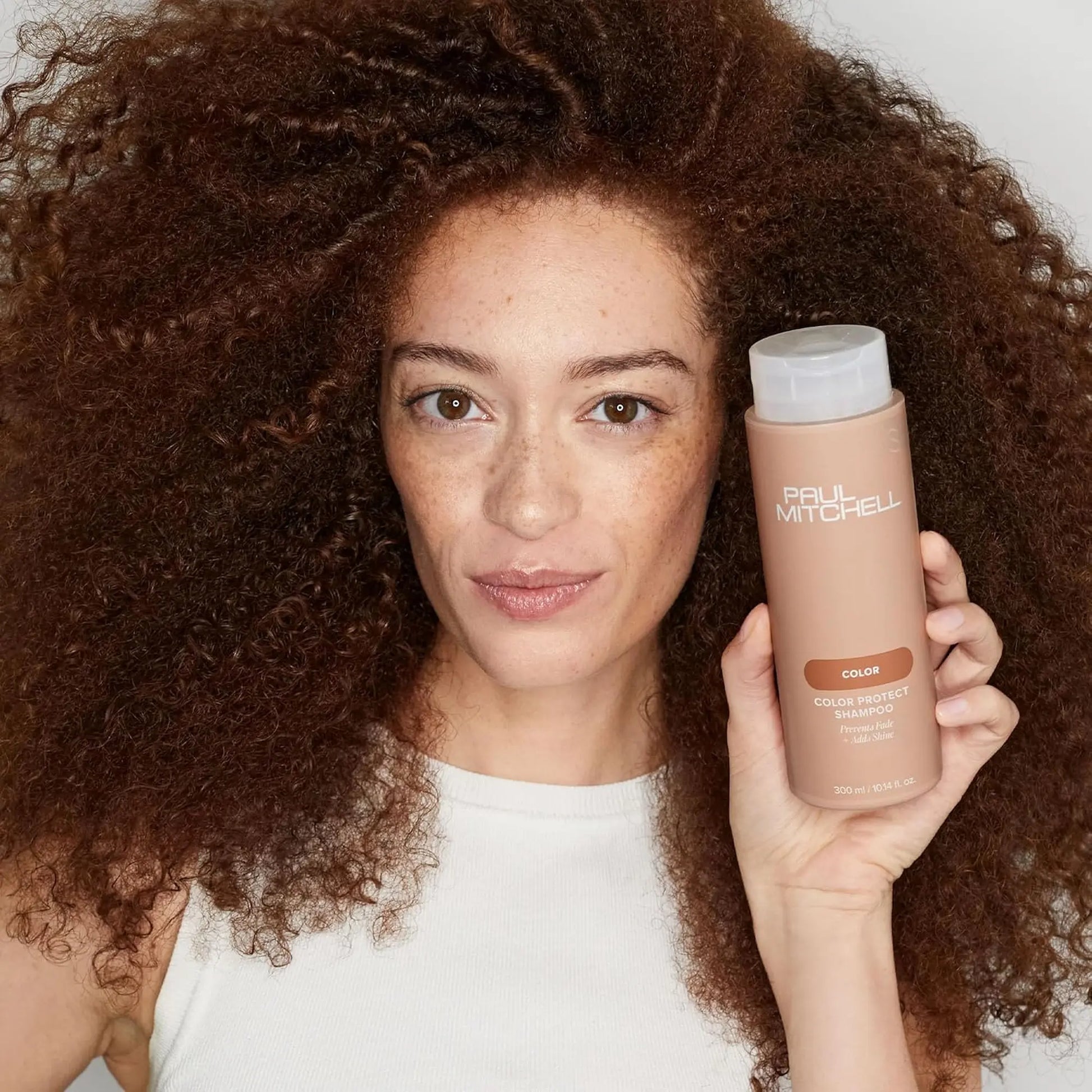 Flacon de shampoing Paul Mitchell Color Protect 300ml : couleur pêche avec bouchon blanc, pour protéger la couleur des cheveux et ajouter de la brillance